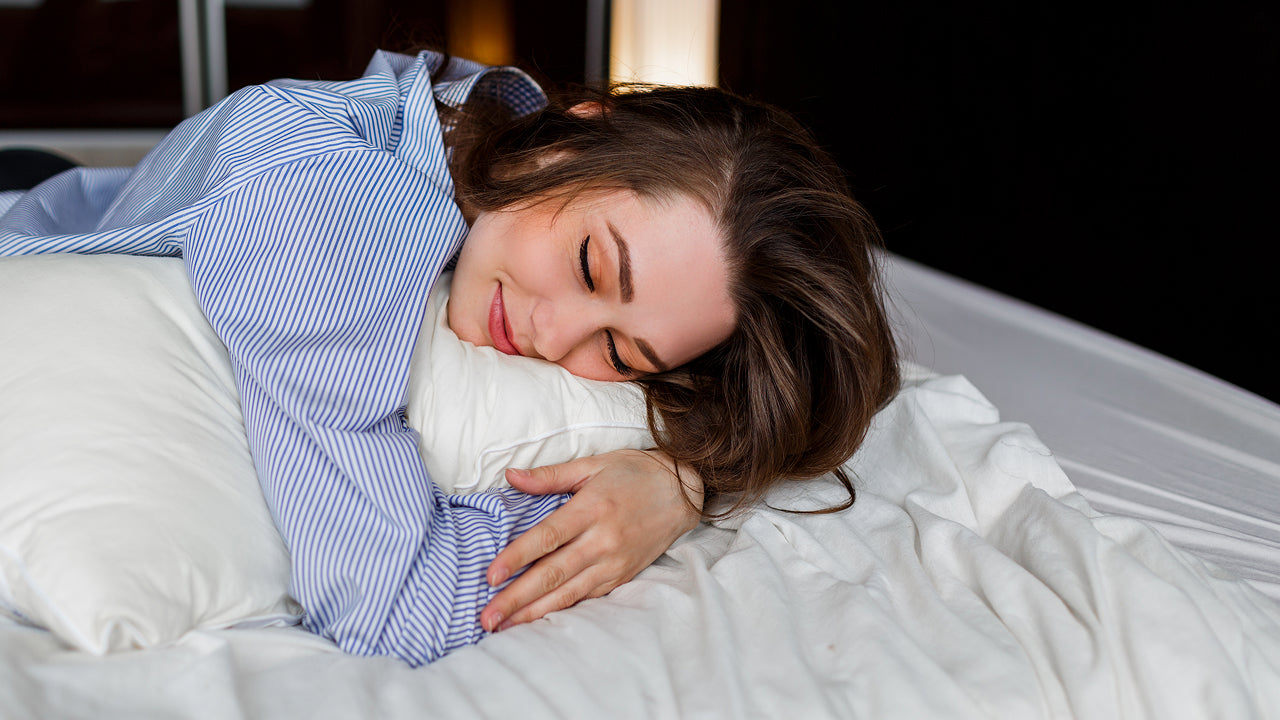 A girl in pjs sleeping peacefully on mattress topper and soft pillow