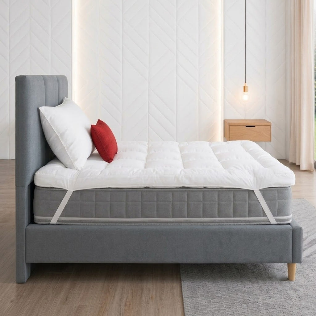 side view of a mattress topper on a grey mattress and wooden bed with a bright red pillow and a front nature view
