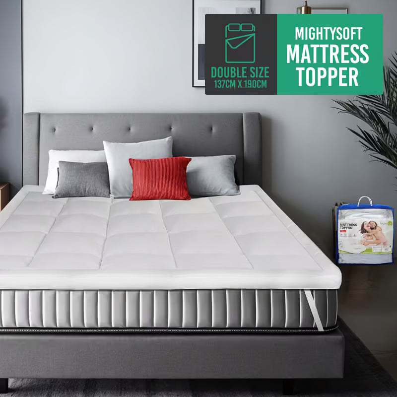 Gray bed with a white mattress topper and pillows