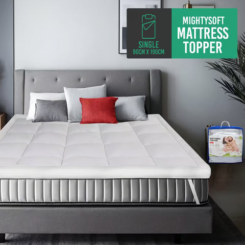 White mattress topper securely fit on a grey bed with pillows