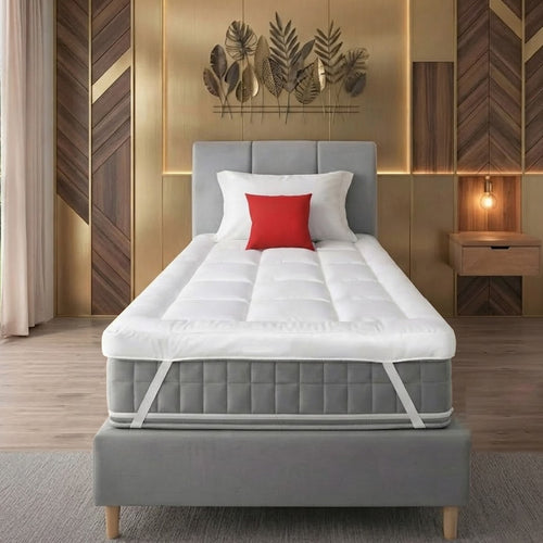 front view of a white small single mattress topper on the grey mattress and bed with red and white pillows