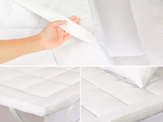 White mattress protector with a hand holding it's secure fit strap