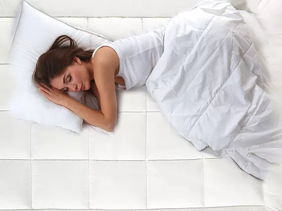 Woman sleeping peacefully on a hypoallergenic bed topper