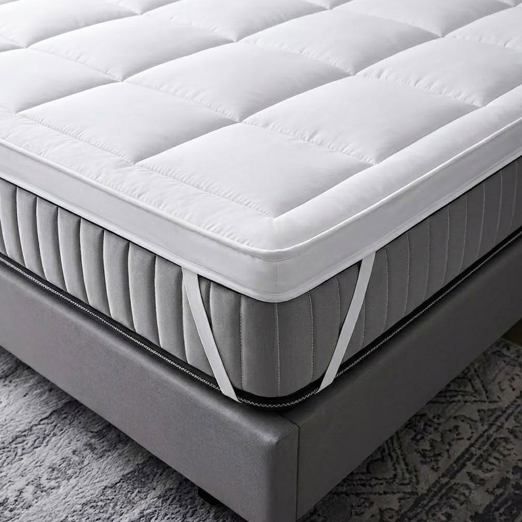 Gray mattress on a bed frame with a textured gray carpet in the background
