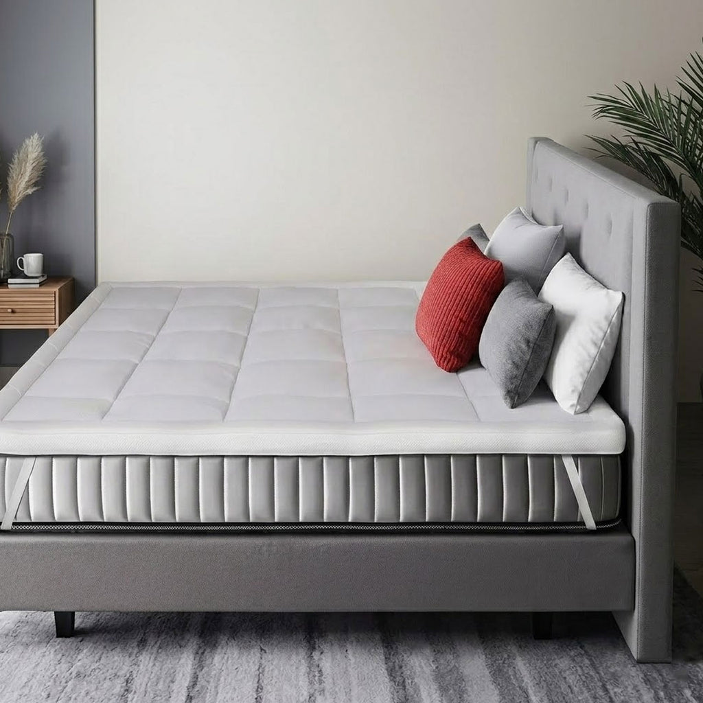Gray bed with white mattress and colorful pillows in a bedroom setting.